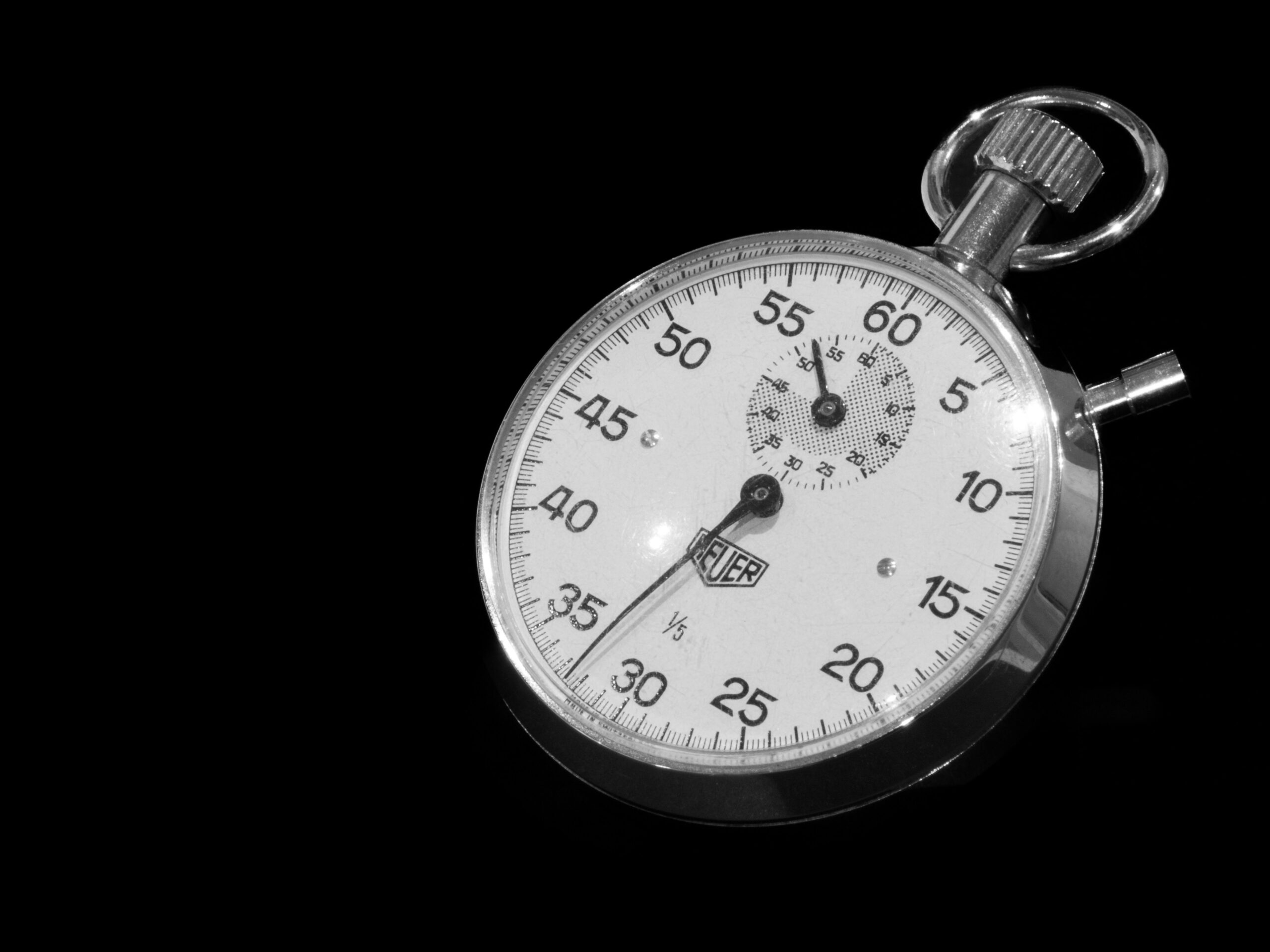 A close-up of a stopwatch on a black background (https://unsplash.com/photos/a-close-up-of-a-stopwatch-on-a-black-background-VwqMTcsb0Tg)